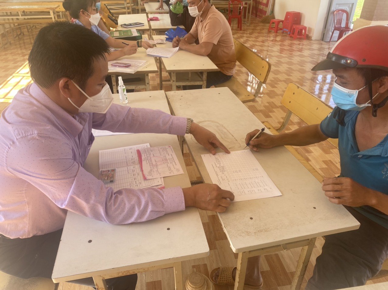 Cán bộ Ngân hàng Chính sách xã hội huyện đang đối chiếu số tiền vay với khách hàng tại xã Đăng Hà